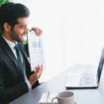 person in front of a computer sitting at adesk